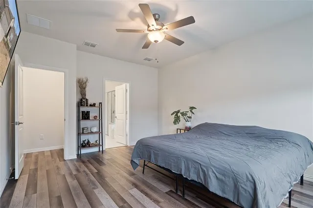 a bedroom with a large bed closet and a ceiling fan