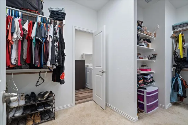 a view of walk in closet with clothes and shoes