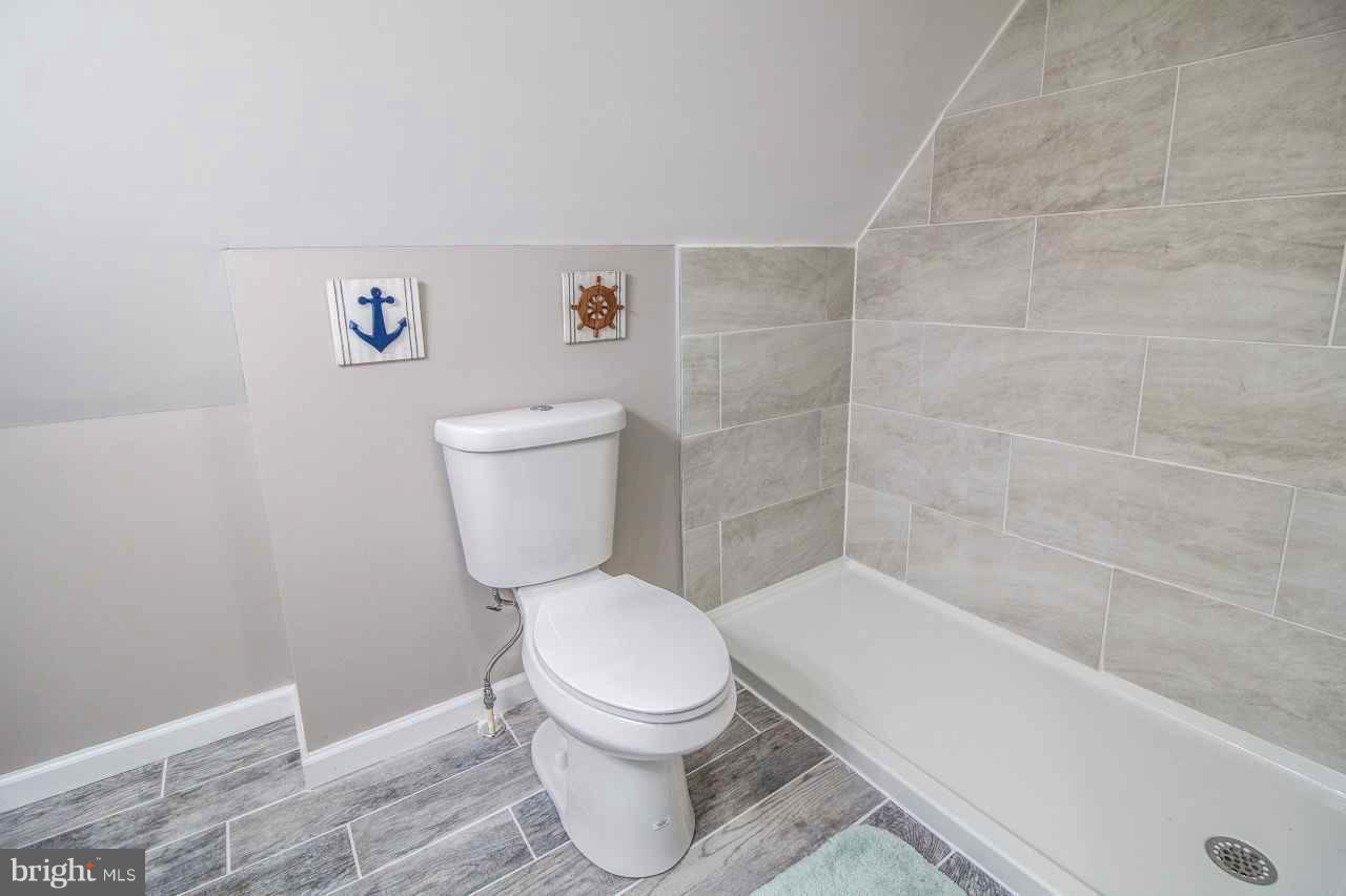 37 Northship Road Baltimore, MD 21222 - Photo 17 of 23 a white toilet sitting next to a bath tub and a shower