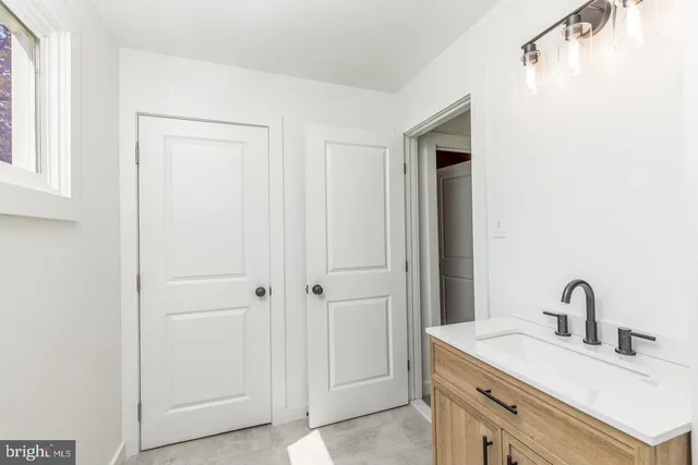 a view of an empty room with wooden floor and a ceiling fan