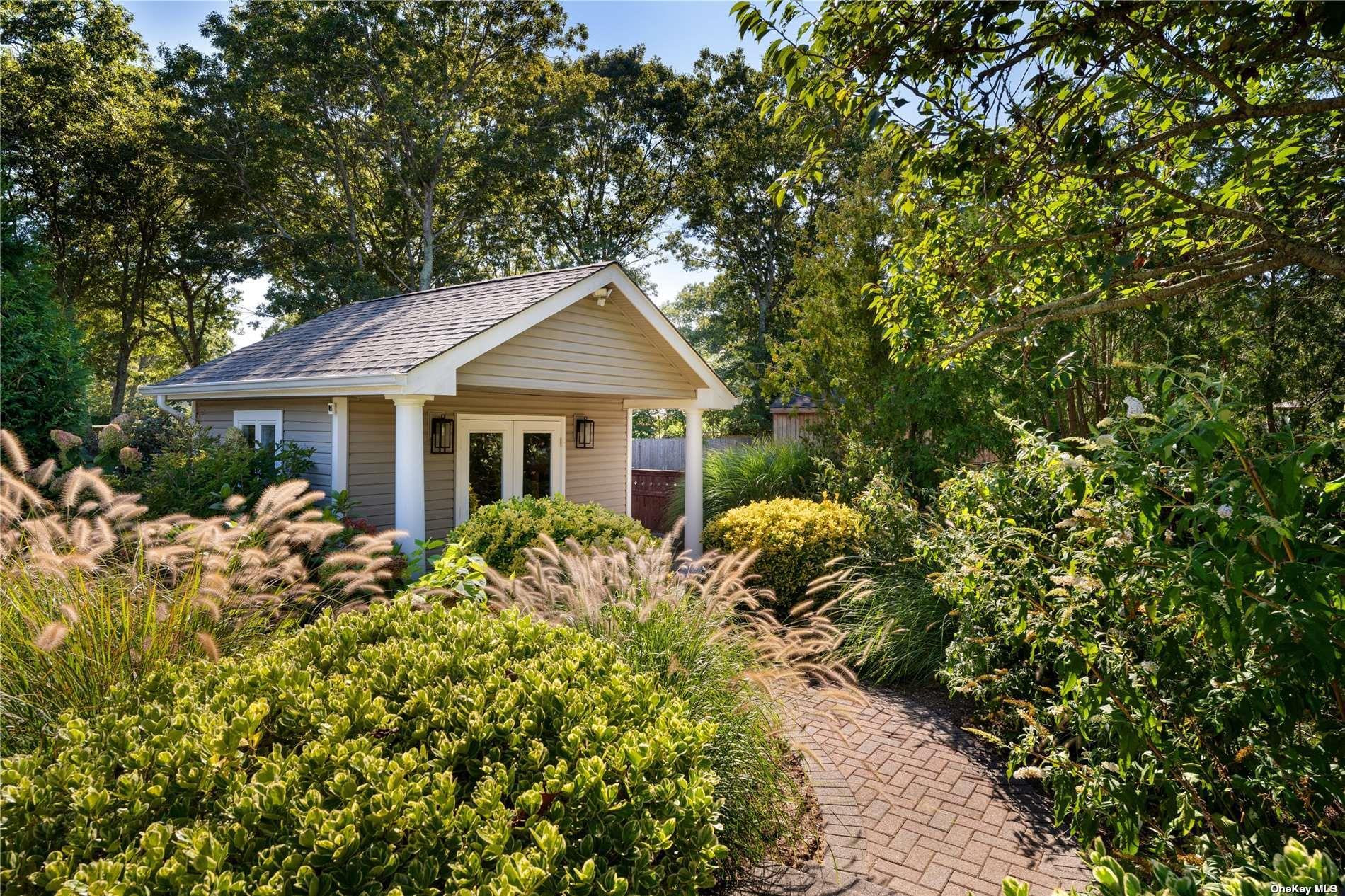 60 Lynncliff Road Hampton Bays, NY 11946 - Photo 15 of 35 a front view of a house with a garden