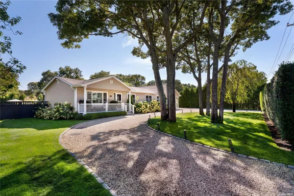 a front view of a house with yard and green space