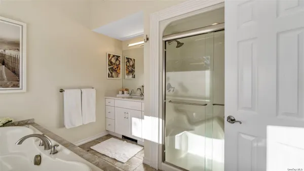 a bathroom with a tub sink and mirror
