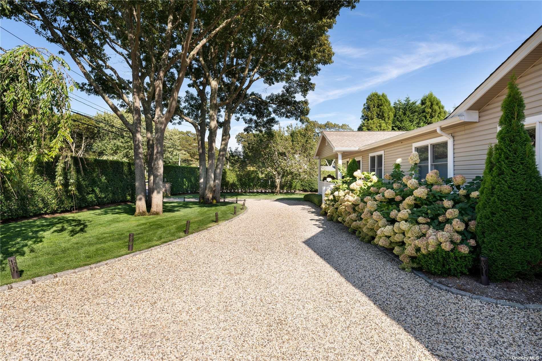 60 Lynncliff Road Hampton Bays, NY 11946 - Photo 3 of 35 a view of a back yard with a lot of flower plants and wooden fence