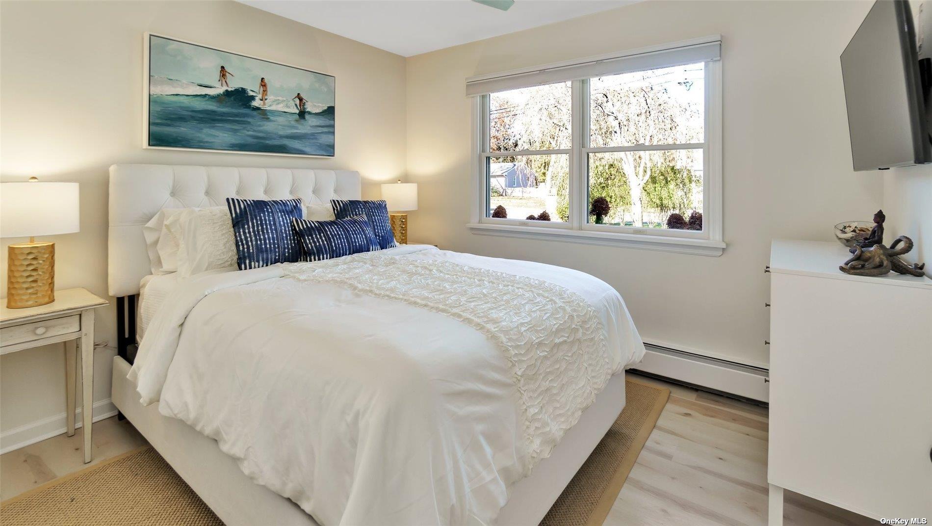 60 Lynncliff Road Hampton Bays, NY 11946 - Photo 33 of 35 a large bed sitting in a bedroom next to a window