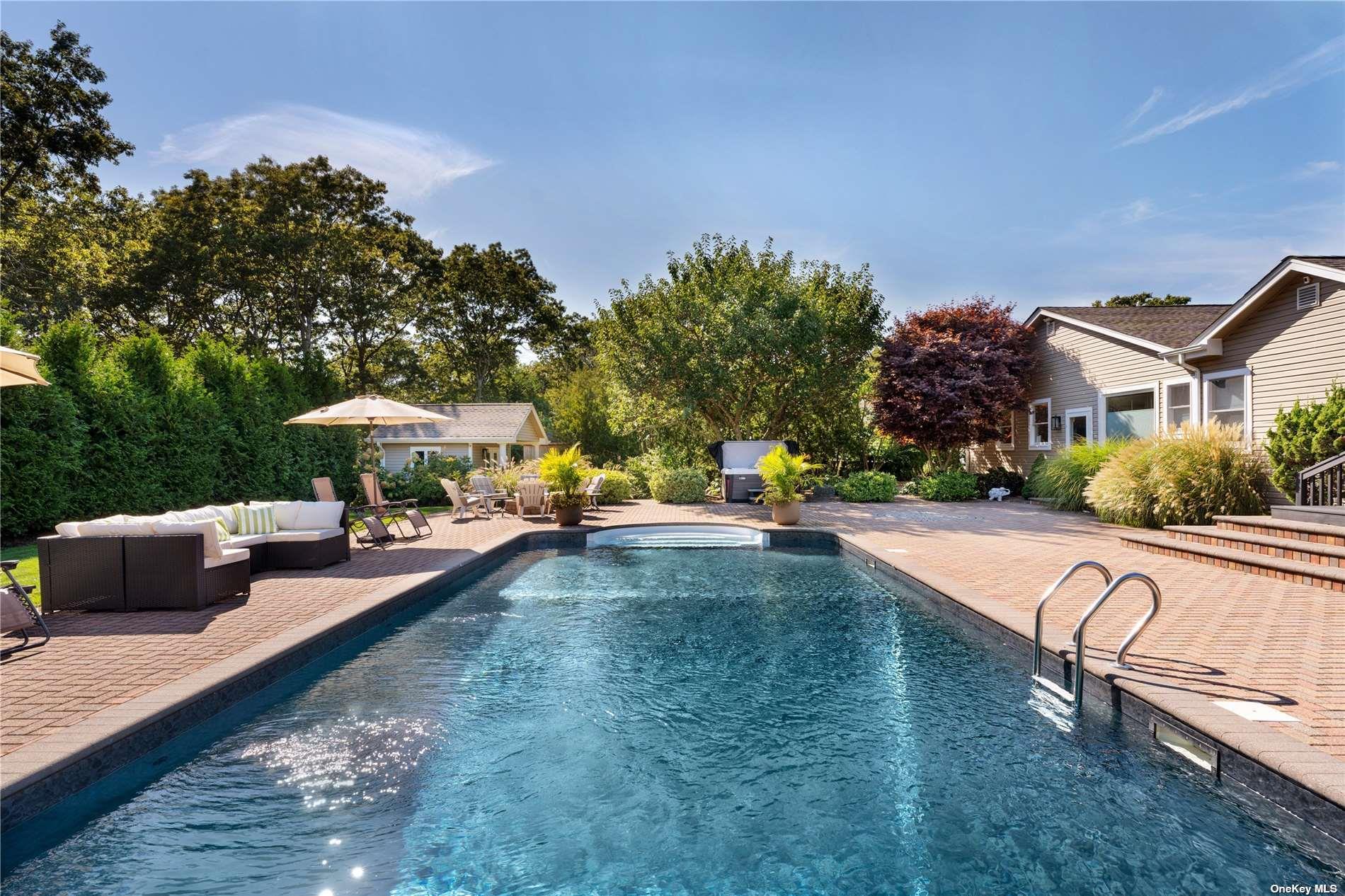 60 Lynncliff Road Hampton Bays, NY 11946 - Photo 5 of 35 a view of swimming pool with outdoor seating and trees in the background
