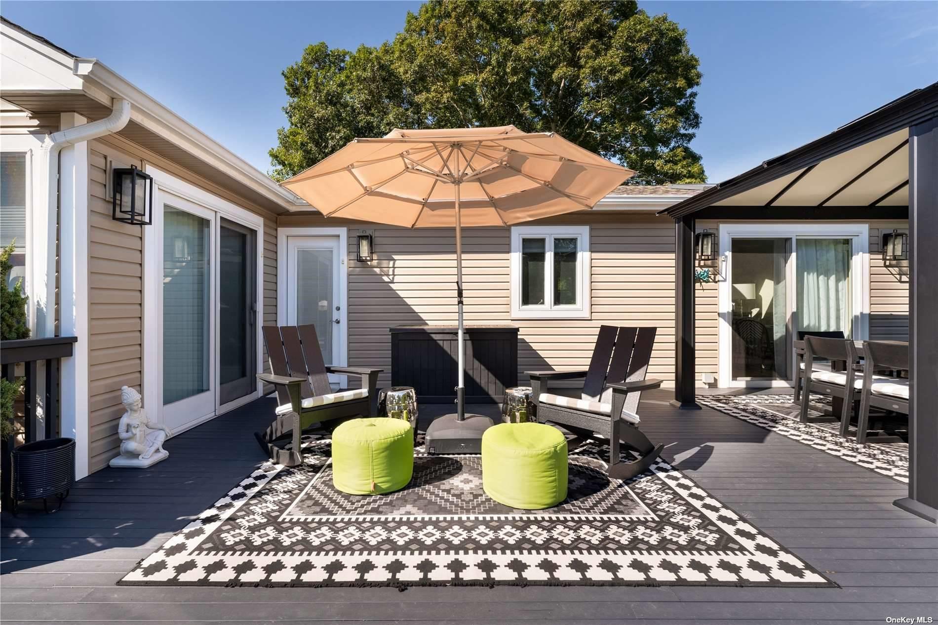 60 Lynncliff Road Hampton Bays, NY 11946 - Photo 8 of 35 a view of a patio with table and chairs and wooden fence