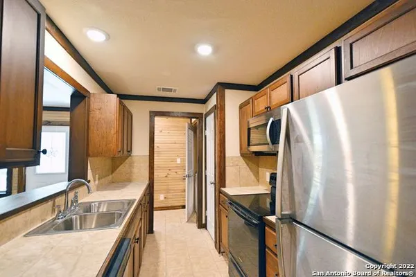 a kitchen with stainless steel appliances granite countertop a refrigerator and a sink