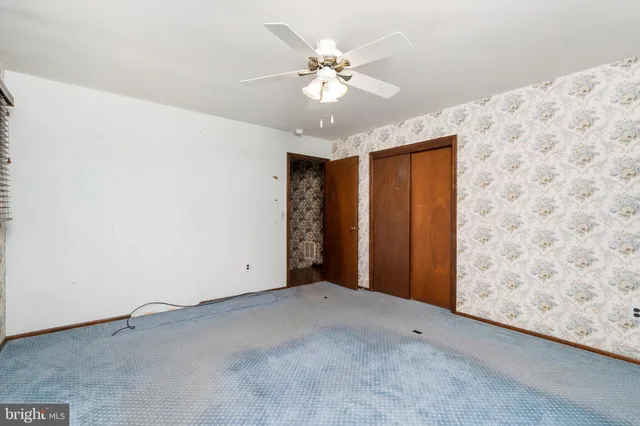a view of an empty room with a ceiling fan