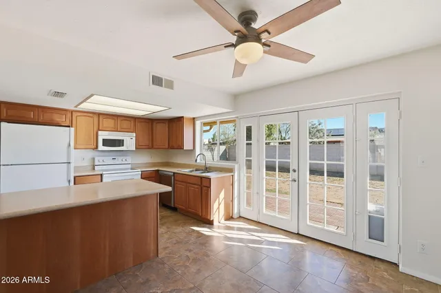 a kitchen with stainless steel appliances granite countertop a stove a sink dishwasher and a refrigerator with wooden floor