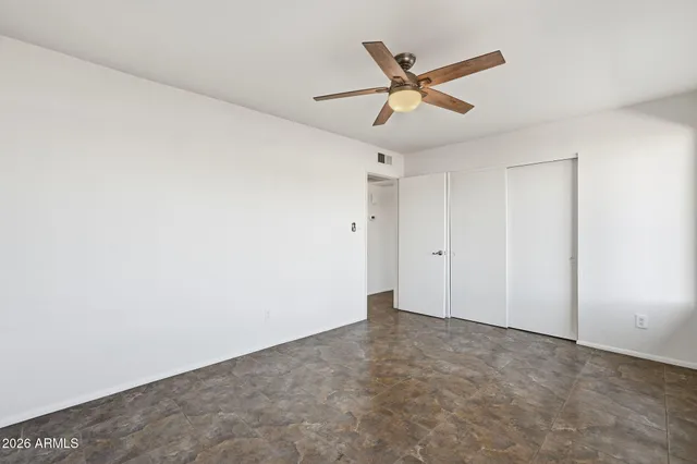 a view of a big room with wooden floor and a ceiling fan