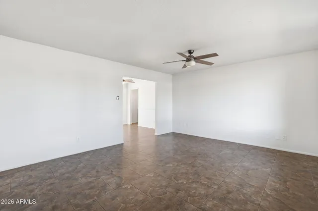 an empty room with a ceiling fan and a window