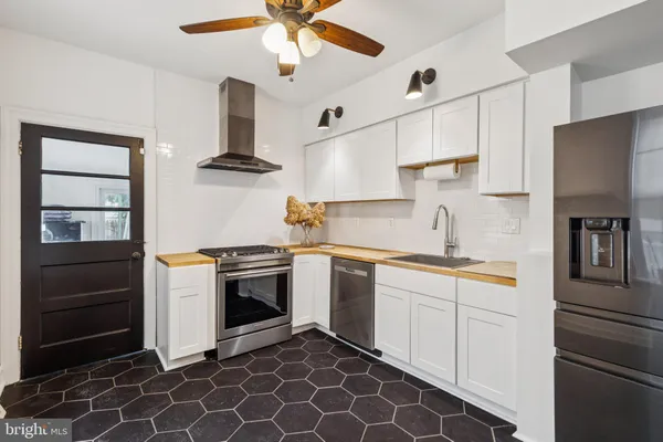 a kitchen with stainless steel appliances a stove a sink and a refrigerator