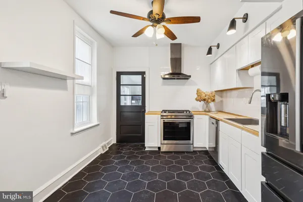 a kitchen with stainless steel appliances granite countertop a refrigerator and a sink