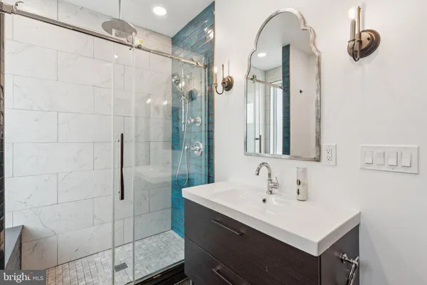 a bathroom with a sink a mirror and shower