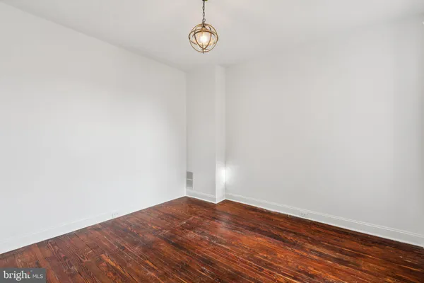 a view of a room with wooden floor and white walls