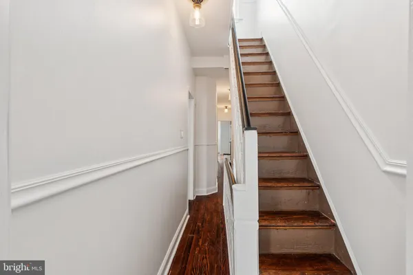 a view of entryway and gallery with wooden floor
