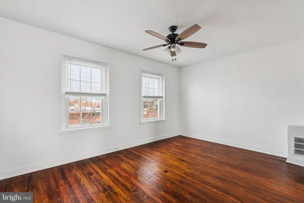 a view of a big room with wooden floor and windows