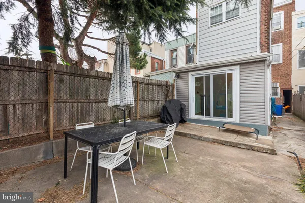 a patio with table and chairs and potted plants