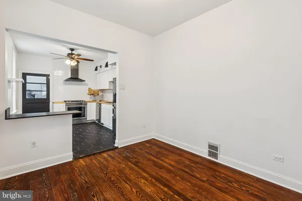 a view of a kitchen with wooden floor and a refrigerator