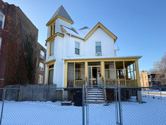 a view of a house with wooden fence and a floor to ceiling window