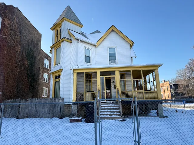 a view of a house with wooden fence and a floor to ceiling window