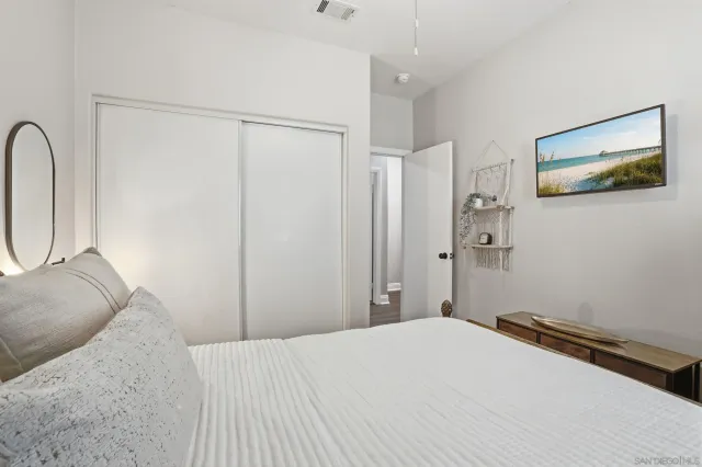 a bedroom with a bed and a painting on the wall