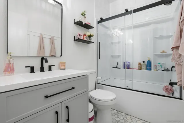 a bathroom with a sink a toilet and shower