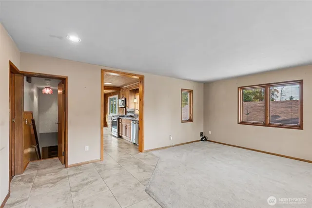 an empty room with entrance and windows