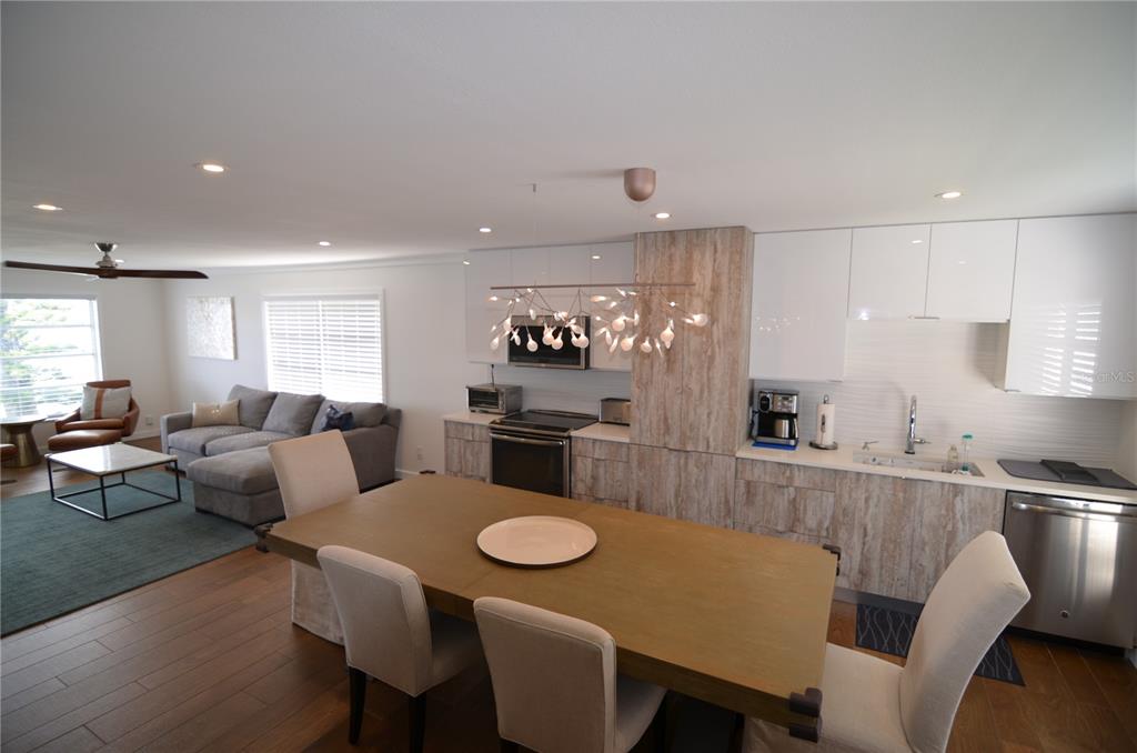 4420 Exeter Drive, Unit 208 Longboat Key, FL 34228 - Photo 4 of 28 a kitchen with stainless steel appliances granite countertop a dining table and chairs