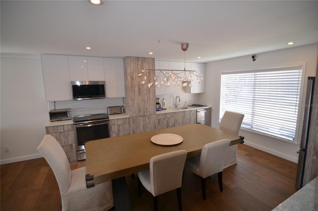 4420 Exeter Drive, Unit 208 Longboat Key, FL 34228 - Photo 5 of 28 a view of a dining room with furniture and wooden floor