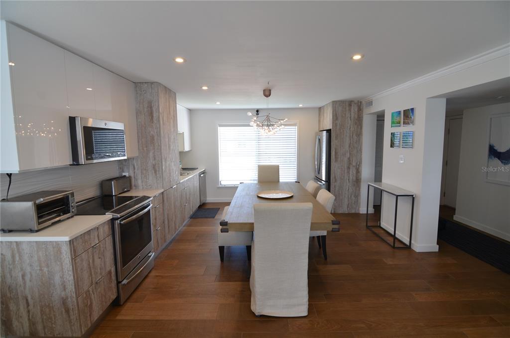 4420 Exeter Drive, Unit 208 Longboat Key, FL 34228 - Photo 6 of 28 a large kitchen with kitchen island a sink a counter top space stainless steel appliances and a window