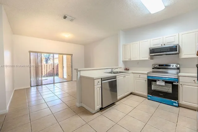 a kitchen with a stove a sink and a refrigerator