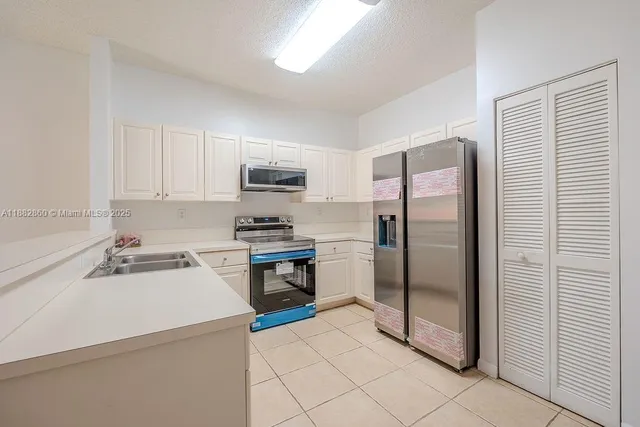 a kitchen with a sink a refrigerator and cabinets
