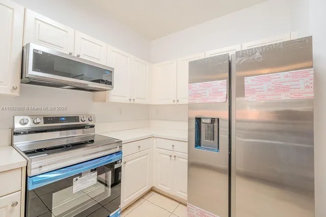 a kitchen with a refrigerator and a stove top oven