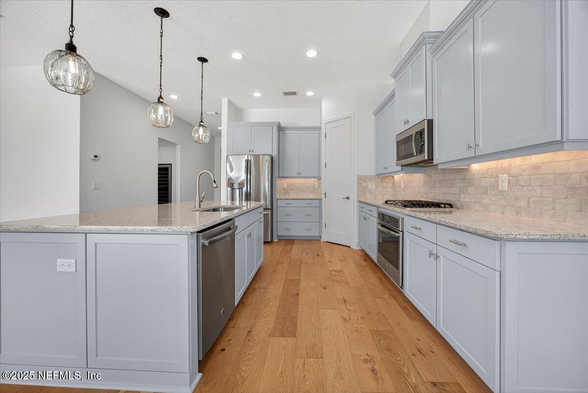 604 Timber Bridge Lane Atlantic Beach, FL 32233 - Photo 14 of 46 a large kitchen with stainless steel appliances kitchen island granite countertop a stove a sink and a refrigerator