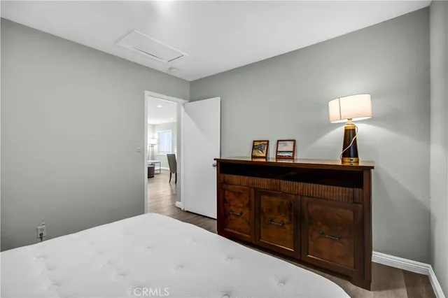 a bedroom with a bed and a lamp on dresser