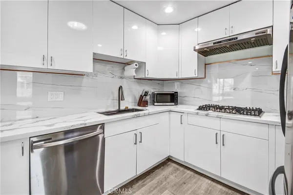 a kitchen with cabinets appliances a sink and a counter top space