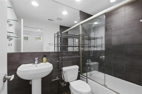 a bathroom with a sink a toilet and a mirror