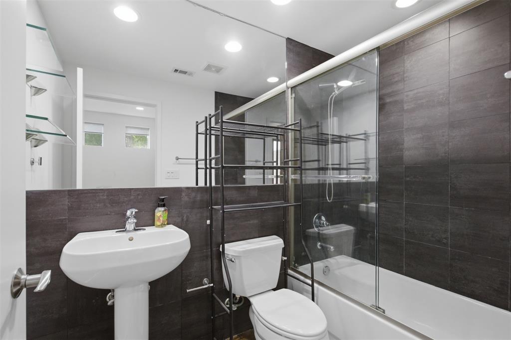 2111 Clark Street, Unit H Dallas, TX 75204 - Photo 5 of 37 a bathroom with a sink a toilet and a mirror