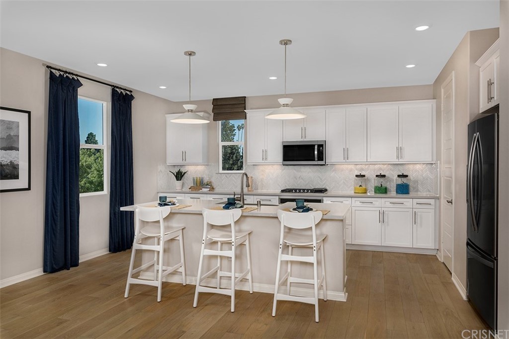 750 Daniel Freeman Circle Inglewood, CA 90301 - Photo 3 of 8 a kitchen with stainless steel appliances kitchen island granite countertop a dining table chairs and white cabinets