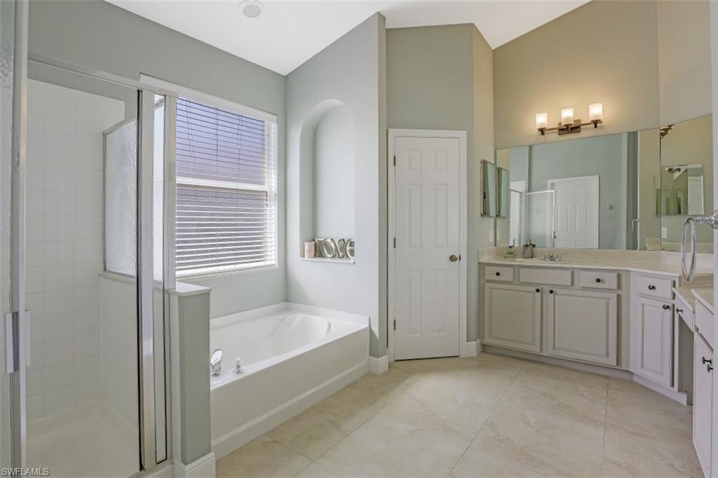 2198 Grove Drive Naples, FL 34120 - Photo 20 of 35 a bathroom with a granite countertop sink a bathtub and a shower