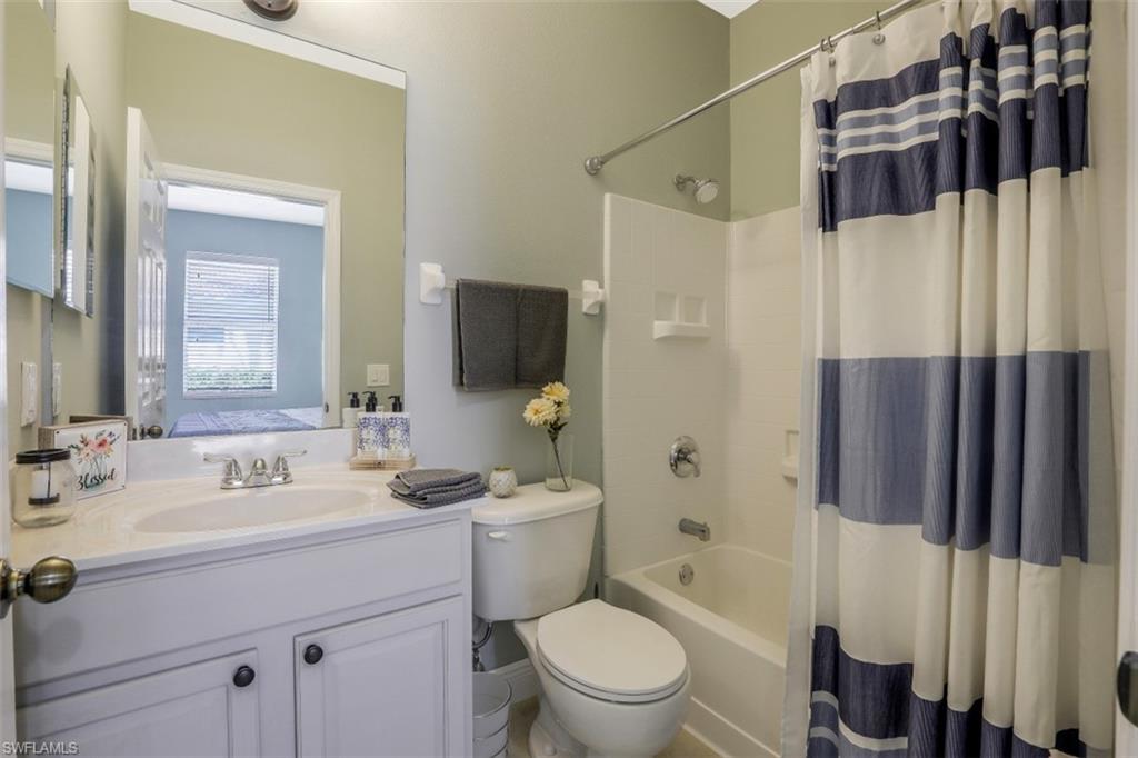 2198 Grove Drive Naples, FL 34120 - Photo 23 of 35 a bathroom with a sink a toilet a mirror a vanity and shower