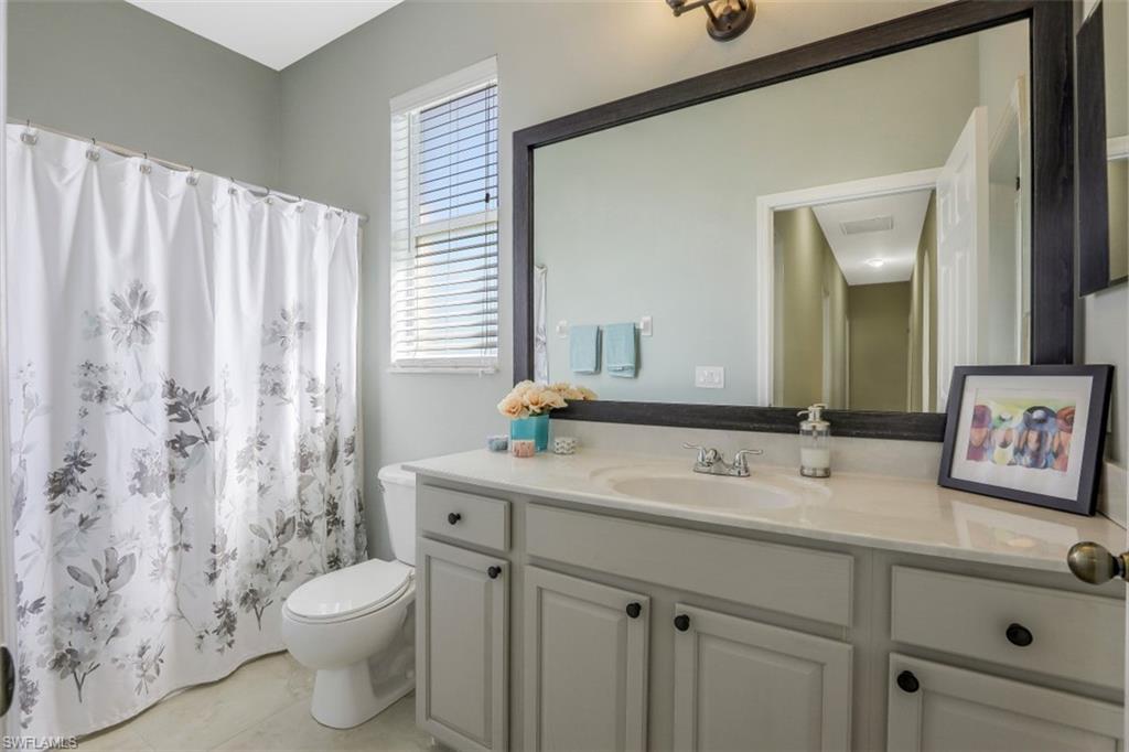 2198 Grove Drive Naples, FL 34120 - Photo 25 of 35 a bathroom with a toilet sink and mirror