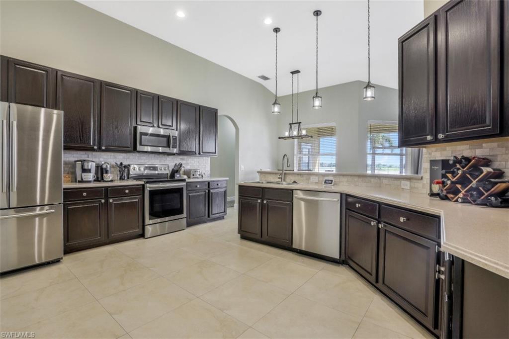 2198 Grove Drive Naples, FL 34120 - Photo 5 of 35 a large kitchen with cabinets stainless steel appliances and a window