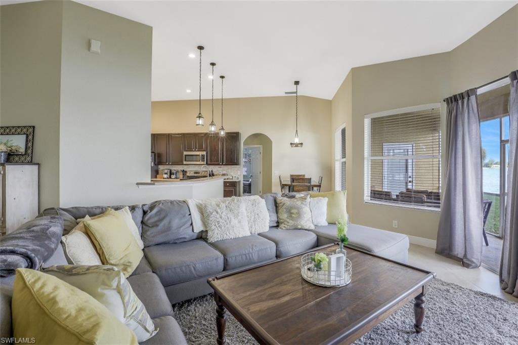 2198 Grove Drive Naples, FL 34120 - Photo 8 of 35 a living room with furniture and a dining table with kitchen view
