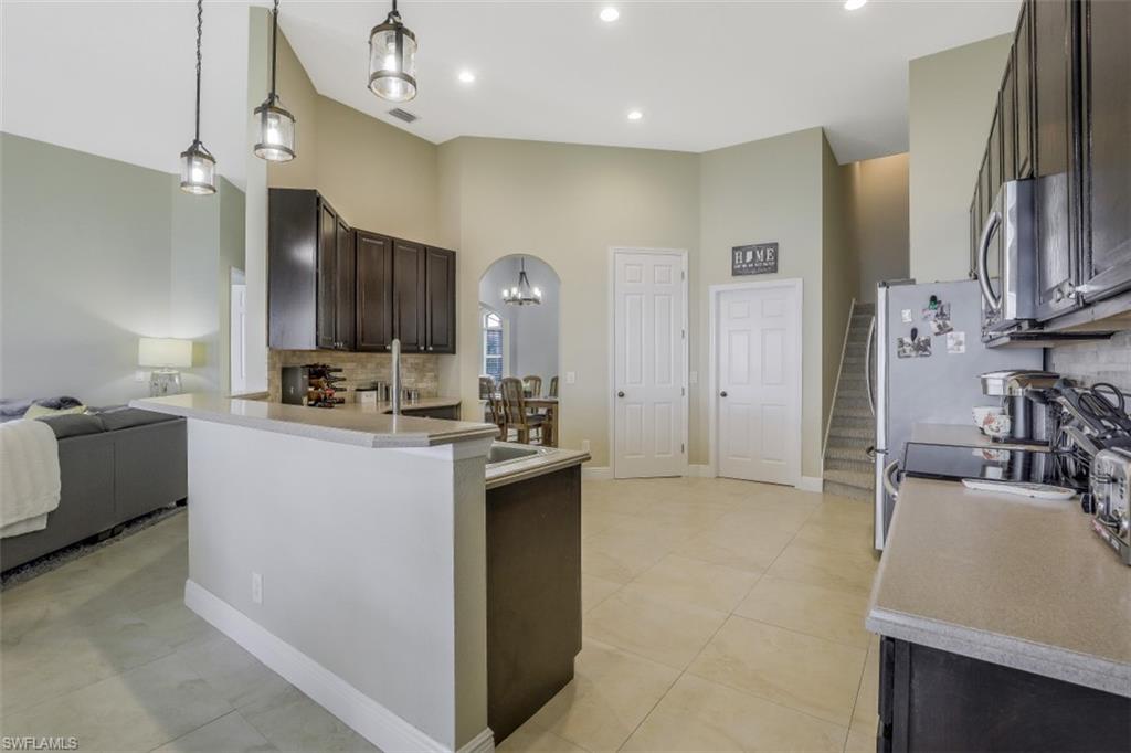 2198 Grove Drive Naples, FL 34120 - Photo 9 of 35 a kitchen with cabinets and a refrigerator