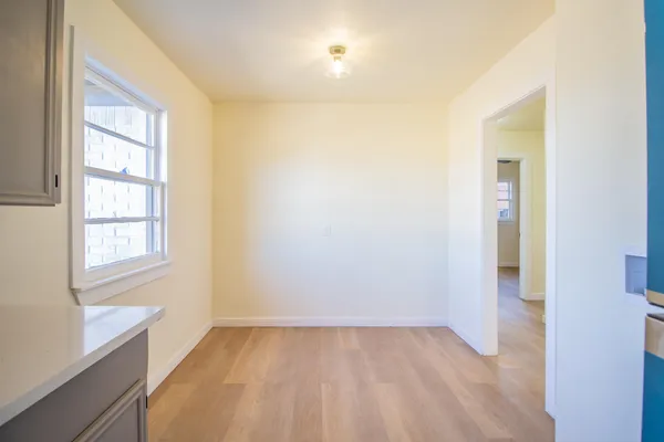 an empty room with windows and fan