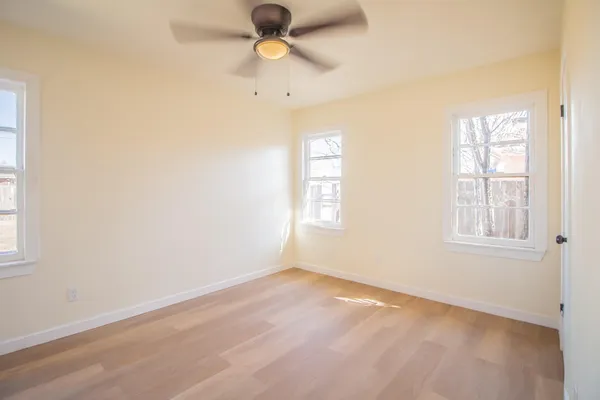 an empty room with a window and a ceiling fan