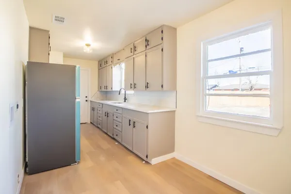 a kitchen with stainless steel appliances granite countertop a sink and a refrigerator
